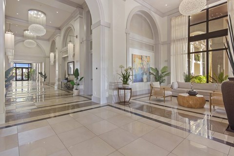 A spacious, well-lit lobby with a marble floor and elegant furniture.
