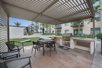 a patio with a table and chairs and a grill at The Sterling at Regent Square, Texas