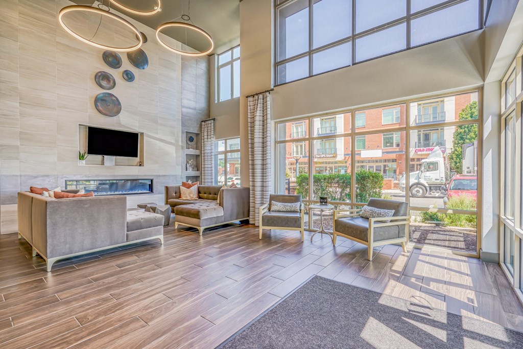 A resident clubhouse with a fireplace and large windows at The District, Denver, CO