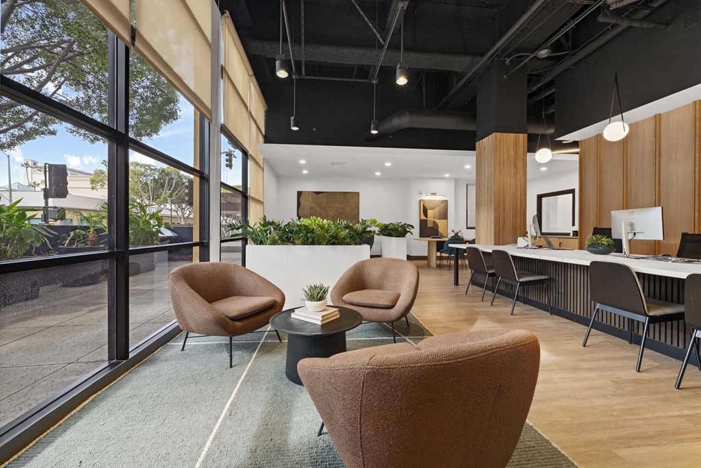 A modern office space with brown chairs and a green rug.