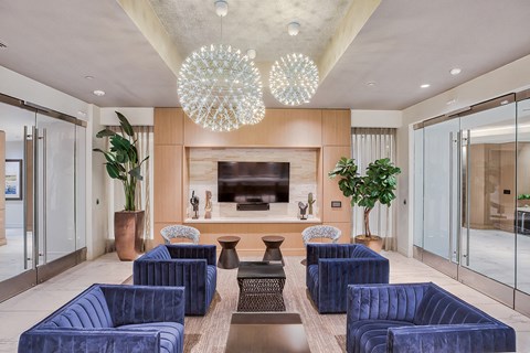 a living room with blue chairs and a television