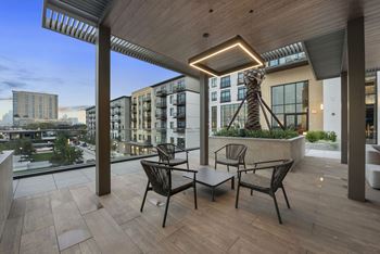 a terrace with a table and chairs and a view of the city at The Sterling at Regent Square, Houston
