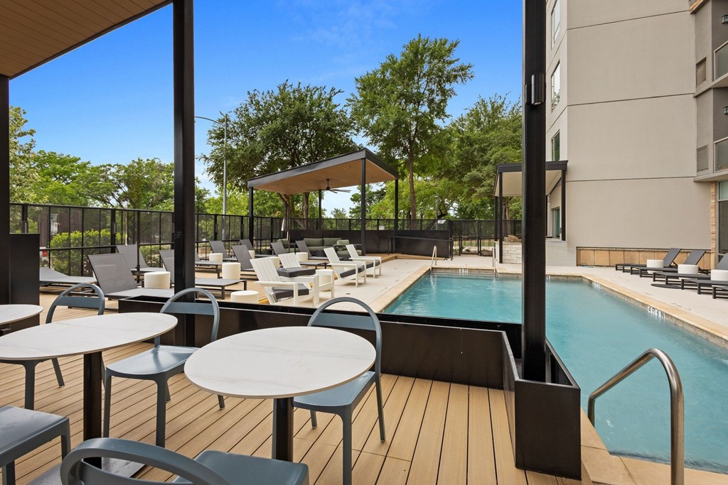 A pool area with a table and chairs.