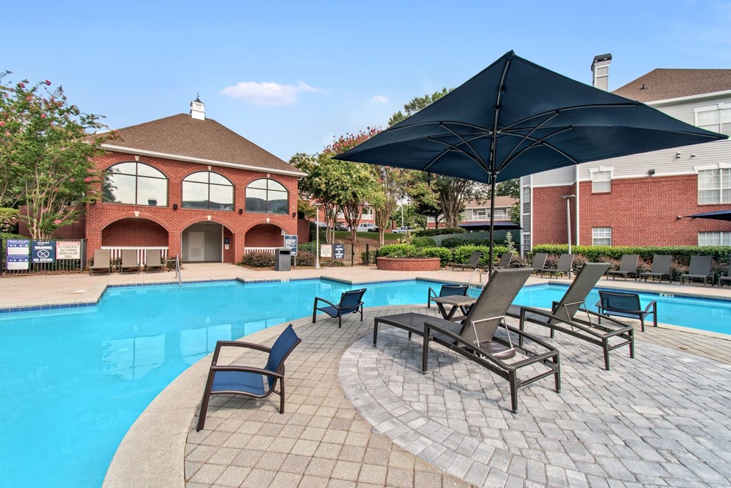 A black umbrella is over a table with four chairs.