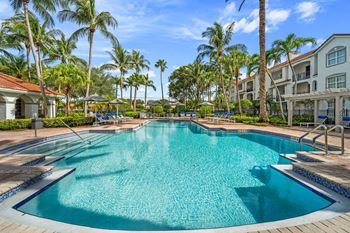a large swimming pool with palm trees in the background