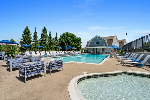 our resort style swimming pool is surrounded by lounge chairs and umbrellas