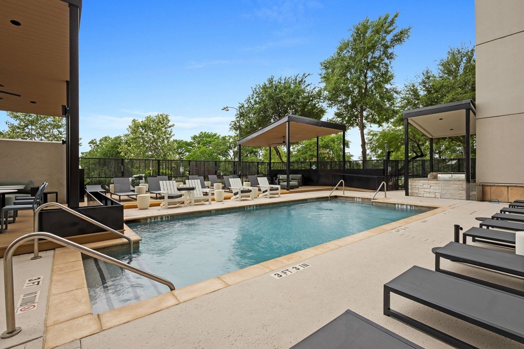 A pool with a slide and sun loungers.