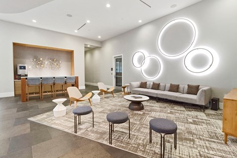 a living room with couches and chairs and a bar with round mirrors