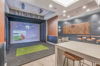 a room with a large projector screen and a table with stools