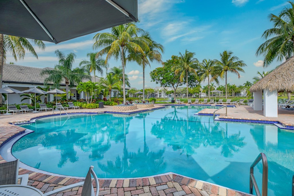 a large swimming pool with palm trees in the background