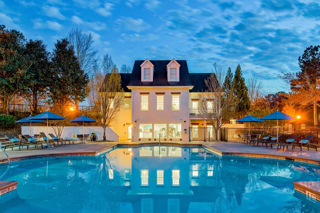 a mansion with a large pool in front of it