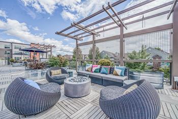 an outdoor patio with wicker furniture and a firepit