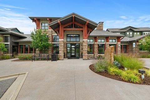 The front of a building with a courtyard and a statue at Windsor Pinehurst, Lakewood, CO