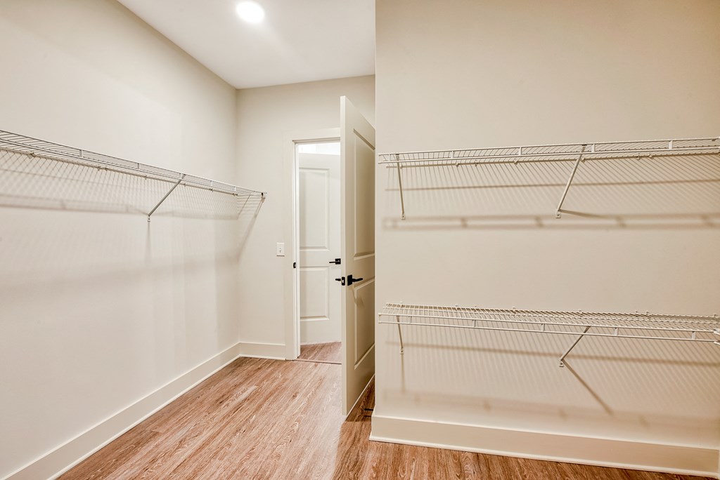 Vinyl plank flooring throughout a bedroom with white walls and wood flooring