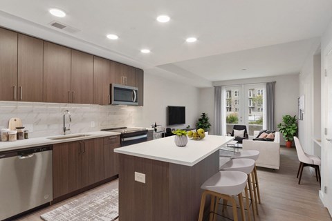 a kitchen with an island and a living room