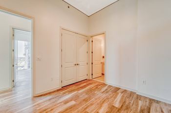 a bedroom with white walls and wood floors