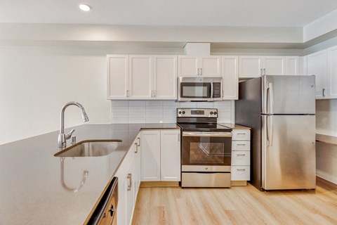 a kitchen with stainless steel appliances and white cabinets