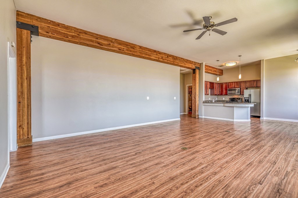A living room with a ceiling fan and a kitchen in the background  at The District, Denver, CO