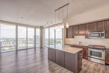a kitchen and living room with wood flooring and large windows