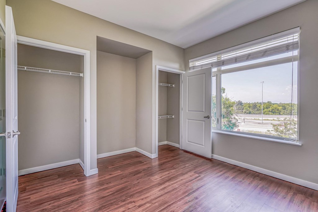 A bedroom with two closets and a large window  at The District, Denver, CO
