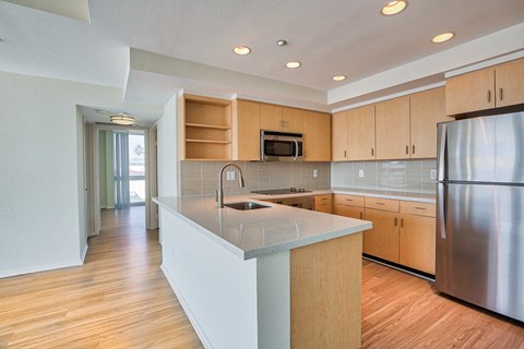 a kitchen with a large island and a stainless steel refrigerator