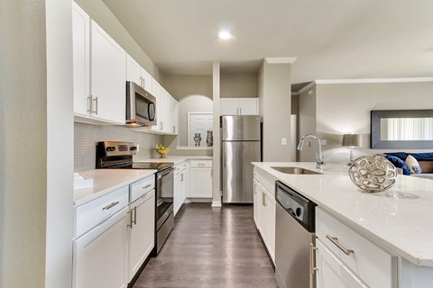 a large kitchen with white cabinets and stainless steel appliances