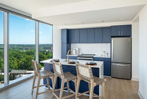 A kitchen with a table and chairs with a view of the city.