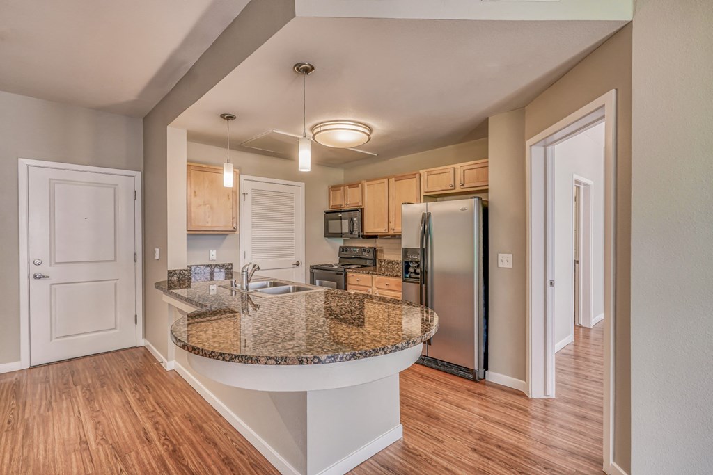 A kitchen with granite countertops and stainless steel appliances at The District, Denver, CO