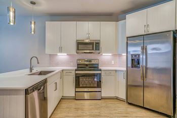 a kitchen with white cabinets and stainless steel appliances