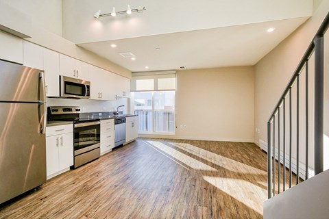 a spacious kitchen with stainless steel appliances and white cabinets