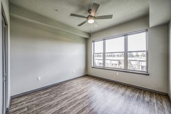 a bedroom with a ceiling fan and a large window