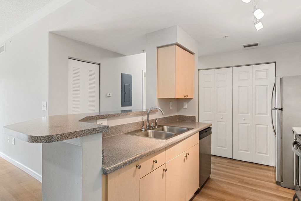 A kitchen with granite countertops and stainless steel appliances at The Winston by Windsor, Pembroke Pines, Florida