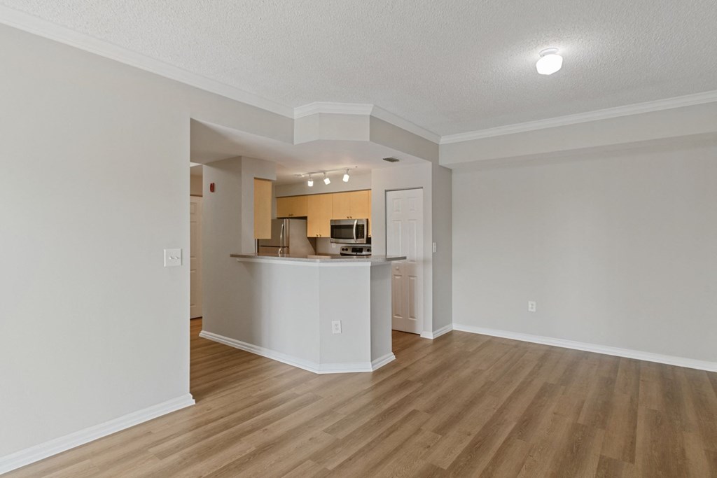 An empty living room with a kitchen in the background at The Winston by Windsor, Pembroke Pines, Florida