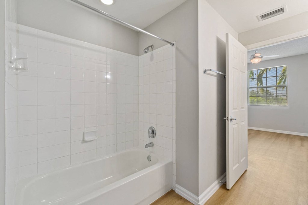 A bathroom with white tiles and a white shower at The Winston by Windsor, Pembroke Pines, Florida