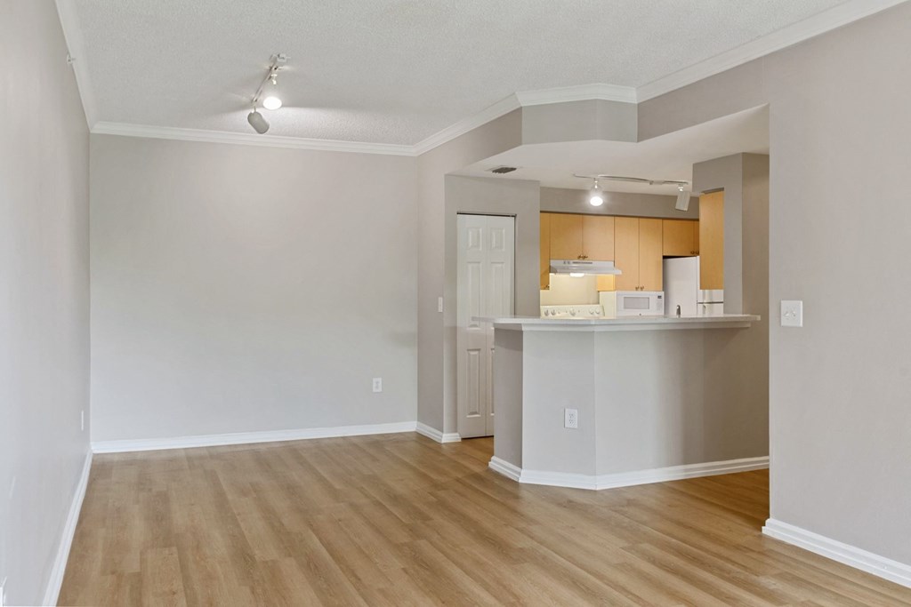 An empty living room with a kitchen in the background at The Winston by Windsor, Pembroke Pines, Florida