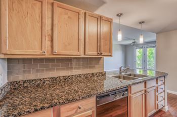a kitchen with granite countertops and wood cabinets