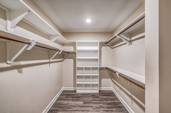 a spacious walk in closet with white shelves