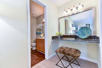 a vanity with a large mirror and a stool