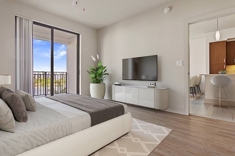A bedroom with a large bed, a television, and a balcony with a view of the outdoors.