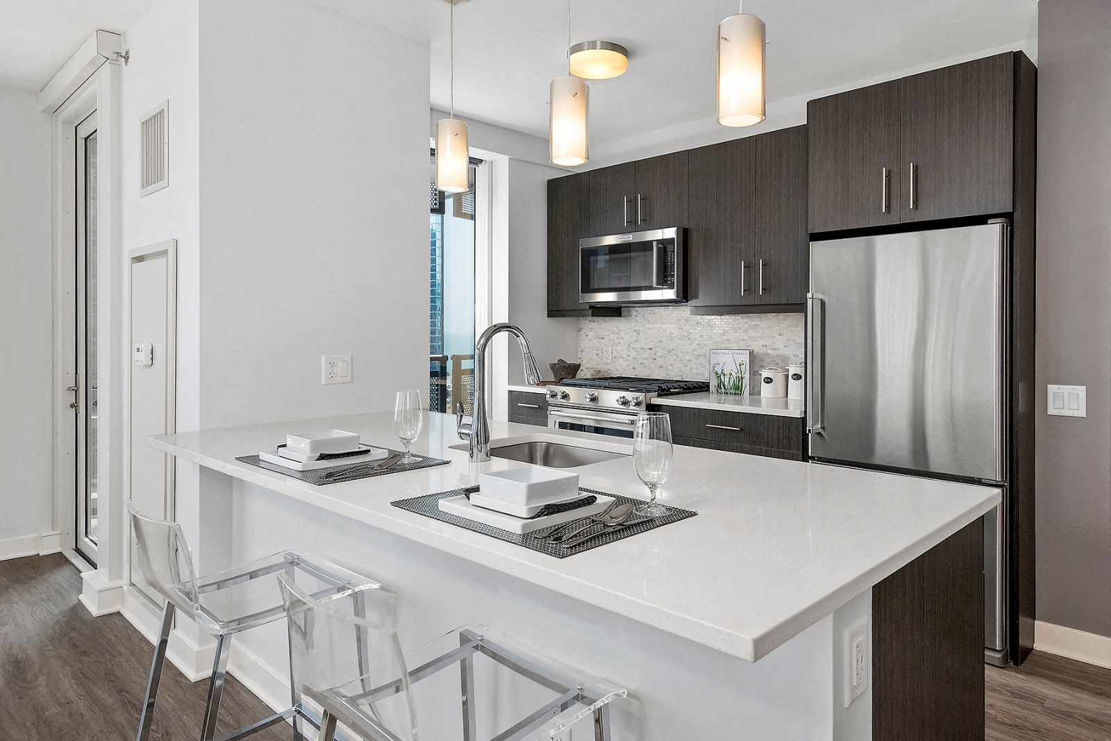 a kitchen with a large island and a stainless steel refrigerator