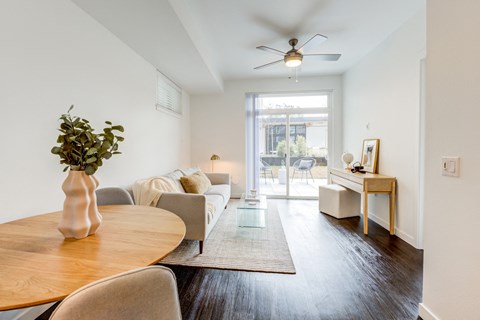 a living room with a couch and a table and a ceiling fan