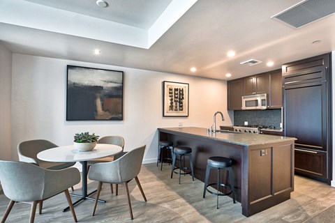a kitchen with a breakfast bar and a table with chairs