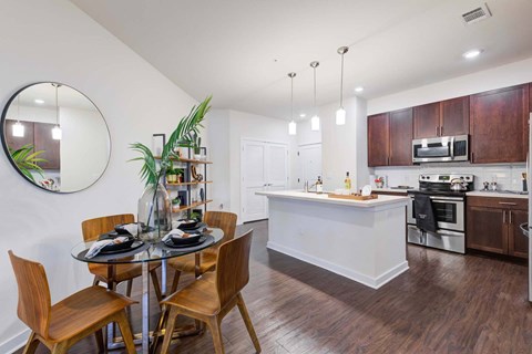 A modern kitchen with a dining table set for four.