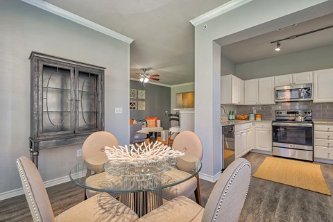 a kitchen and dining room with a glass table and chairs