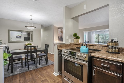 an open kitchen and dining room with a table and chairs and an oven and sink