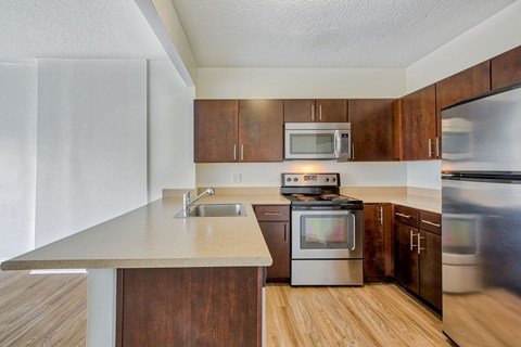 a kitchen with stainless steel appliances and wooden cabinets