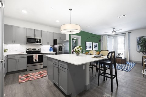 a kitchen with a large island and a table with chairs