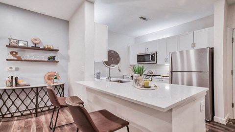 a kitchen with a large counter top and a stainless steel refrigerator