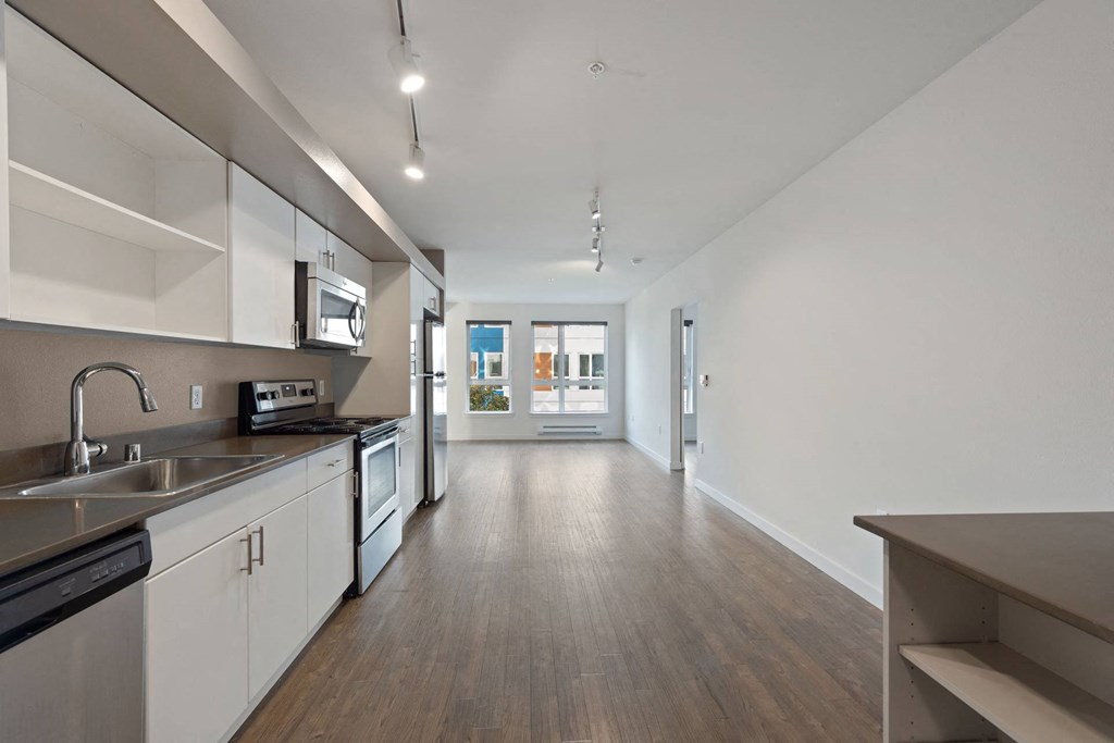 A modern kitchen with white cabinets and stainless steel appliances.