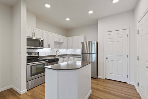 A kitchen with white cabinets and stainless steel appliances.